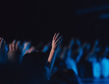 People in worship gathered in a hall with blue light effect